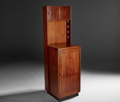 LOT 368 | CHARLES RENNIE MACKINTOSH (1868-1928) | INLAID MAHOGANY BEDSIDE CABINET, 1916 with ebonised plinth and shell-inlaid handles, the upper section with two doors flanked by uprights pierced by squares, the base with single panelled door enclosing a single drawer and a shelf | 36cm wide, 122cm high, 35.5cm deep | Sold for £250,000 incl premium